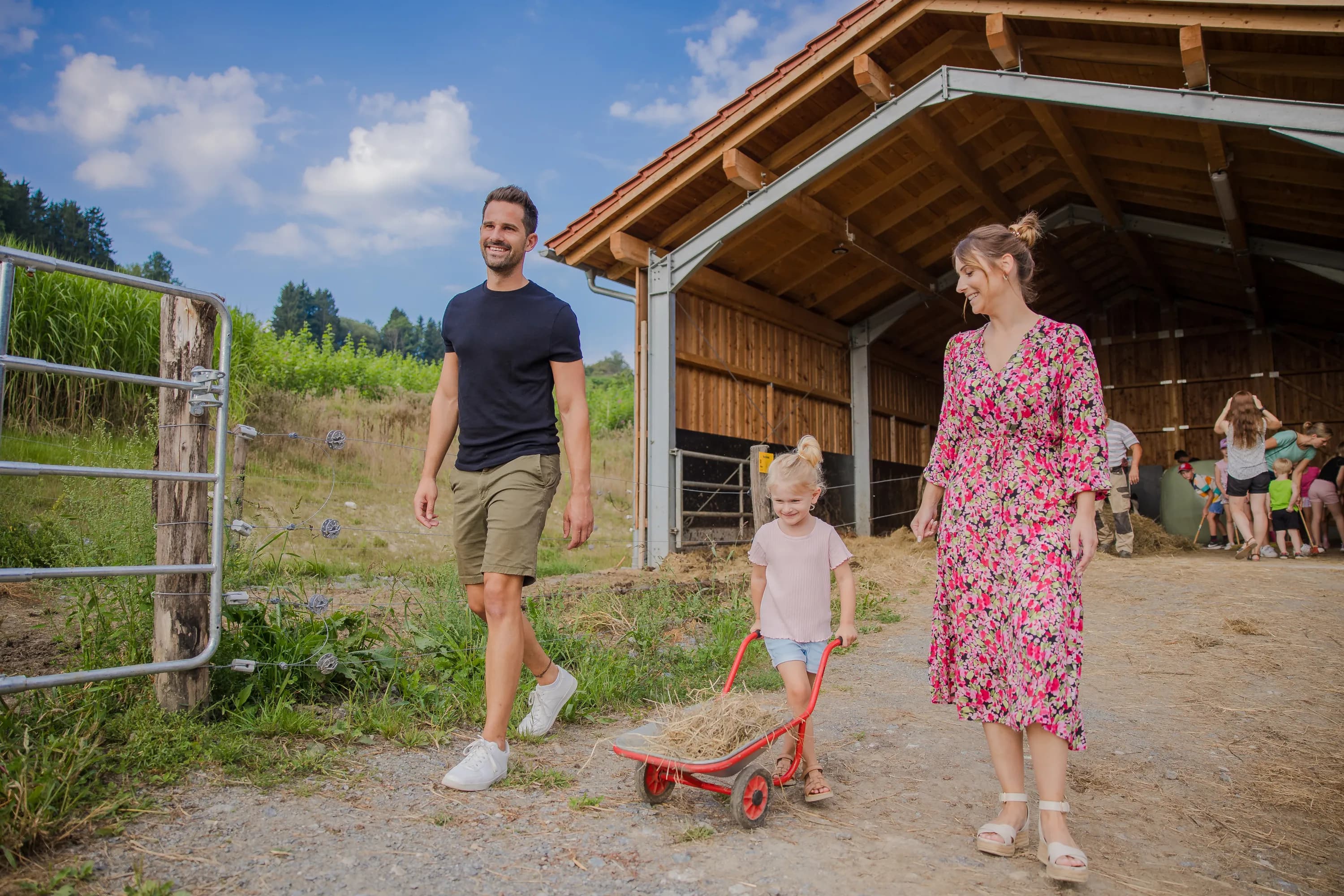 Kind mit seinen Eltern bei der Stallarbeit im Familienhotel Schreinerhof