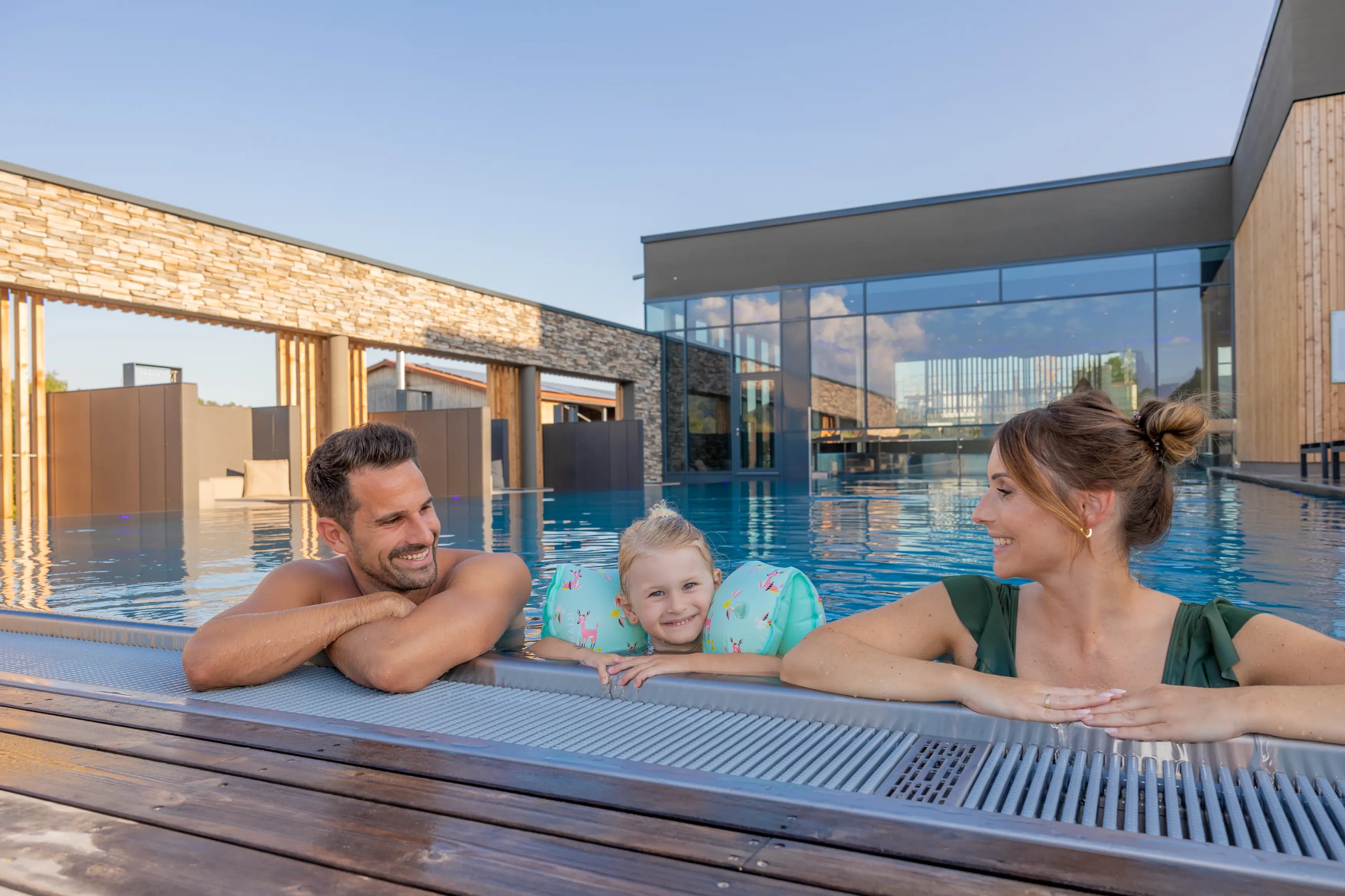 Familien genießen ihren Urlaub im Familienhotel Schreinerhof mit Spielplatz, Pool und Blick auf die Natur im Bayerischen Wald
