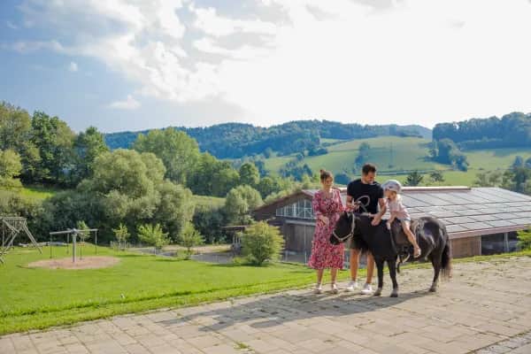 Kind streichelt Pony bei den Reiterferien im Familienhotel Schreinerhof im Bayerischen Wald.