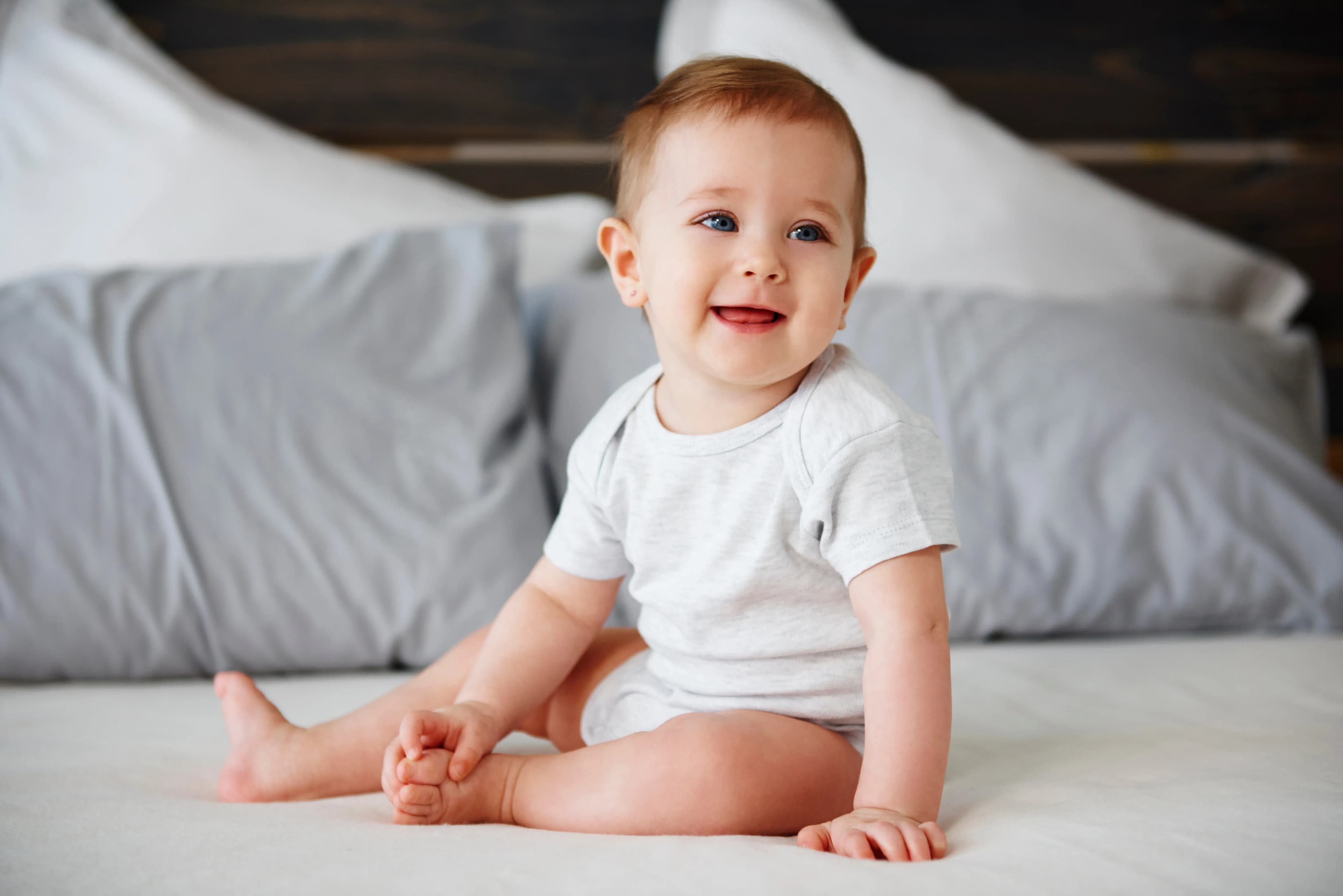 Glückliches Baby im Hotelbett