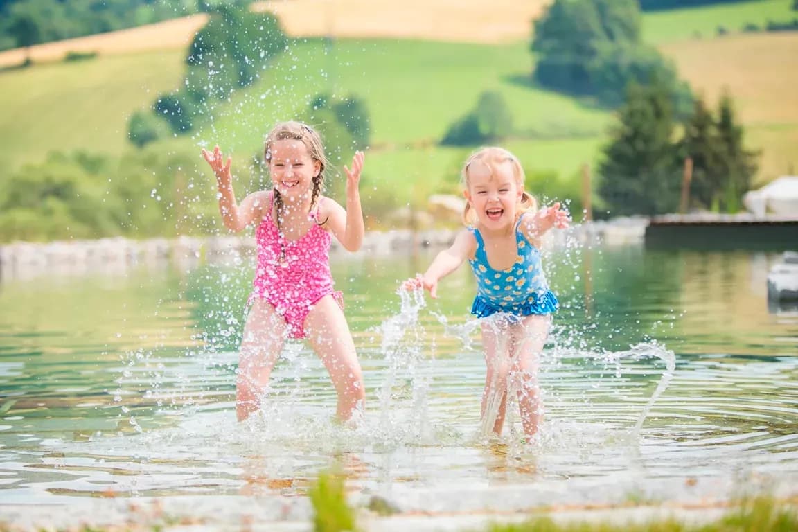 Kinder beim Planschen im Natursee des Schreinerhofs