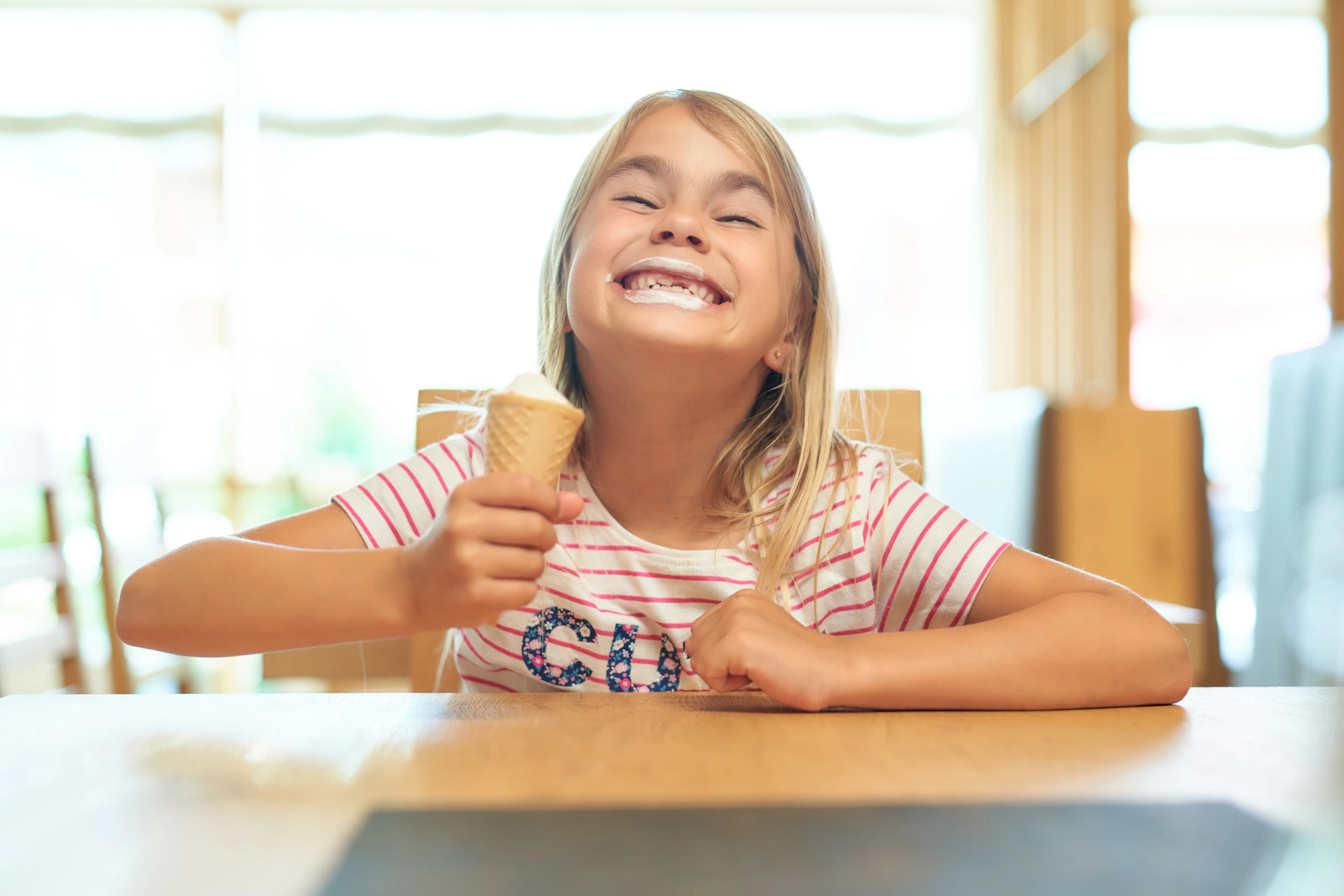 Fröhliches Mädchen beim Eis essen