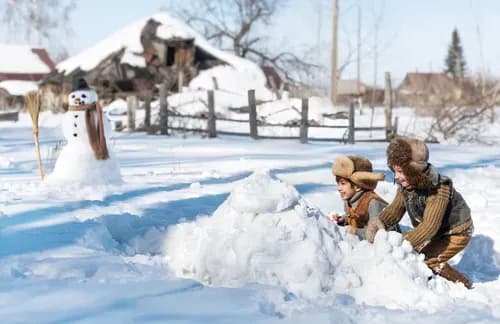 Spielende Kinder in der winterlichen Landschaft des Familienhotel Schreinerhof