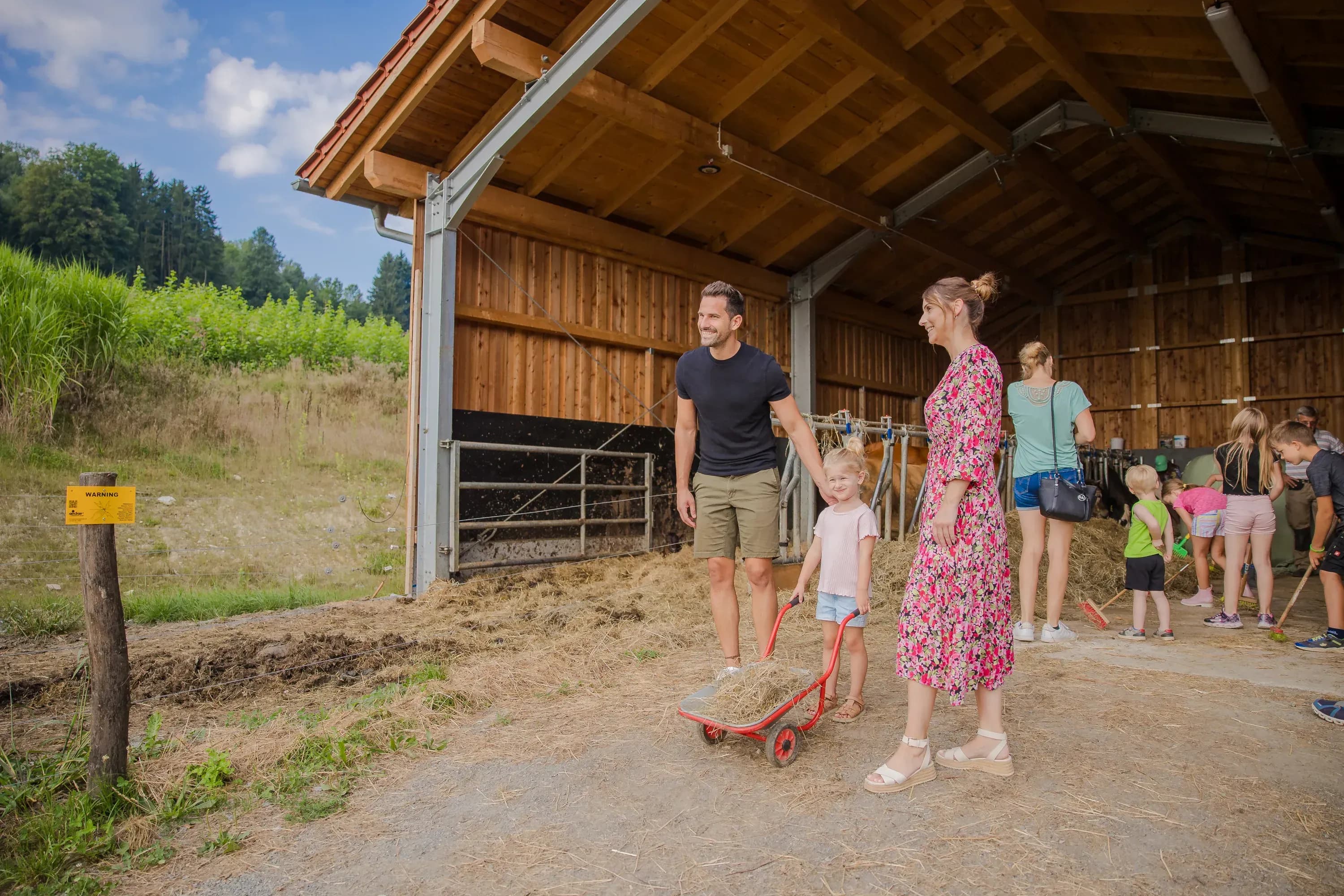 Kinder füttern Tiere und erleben Abenteuer auf dem Bauernhof des Familienhotels Schreinerhof im Bayerischen Wald.