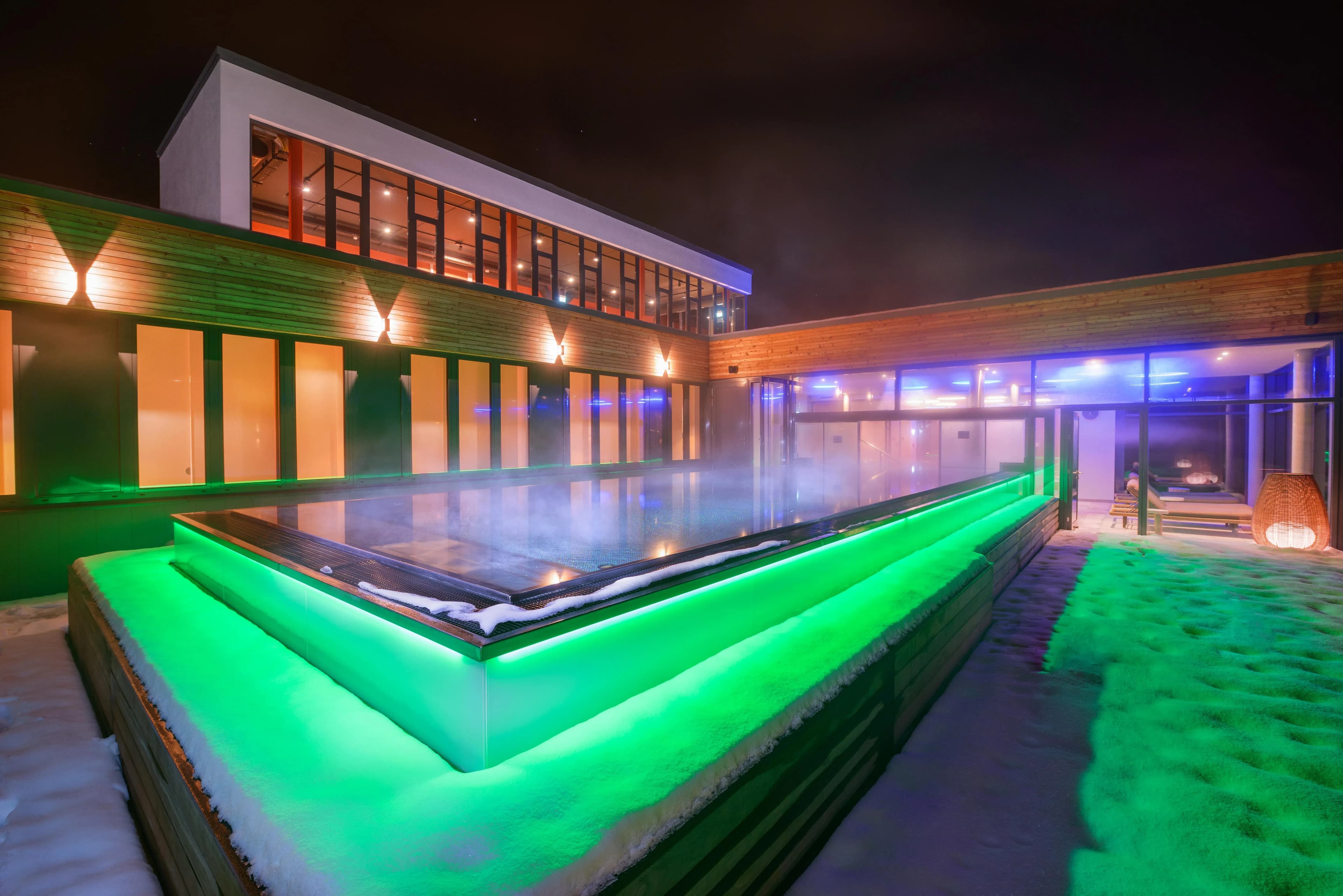 Der dampfende Skypool bei Nacht im Familienhotel Schreinerhof umgeben von Schnee
